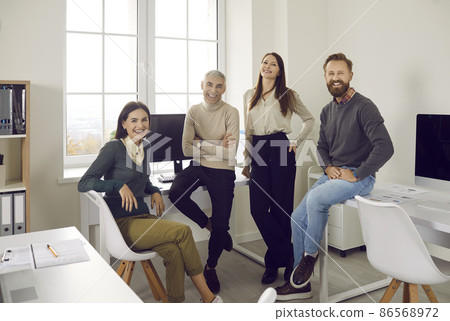 Team of happy young and senior business people in their office. Group portrait of cheerful, positive, smiling corporate employees of different ages in their modern office workplace 86568972