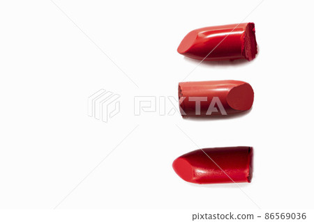 Samples of red lipsticks broken on a white background. Texture of cosmetic products Samples of red lipsticks broken on a white background. Texture of cosmetic products 86569036