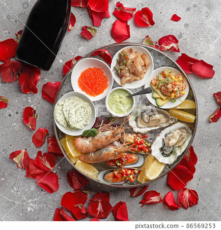 Metal tray with open oysters, raw mussels and caviar. Seafood assortment. On a stone background. Free space for text. 86569253