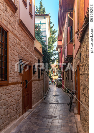 bike parked in a historic narrow lane in Kaleici, the historical city center of Antalya 86569298