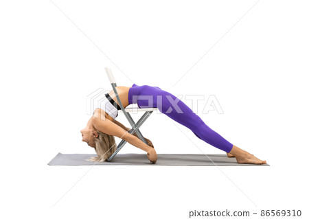 Yoga with props, promo. Fit beautiful woman lying on a chair and stretching her back, isolated on white. 86569310