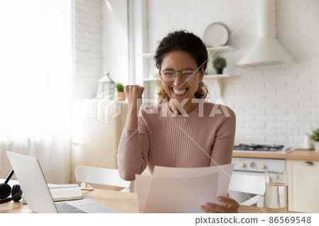 Woman sit in kitchen read paper from bank feels excited Woman sit in kitchen read paper from bank feels excited 86569548