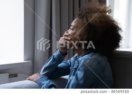 Desperate depressed crying teenage Black girl side candid portrait 86569589