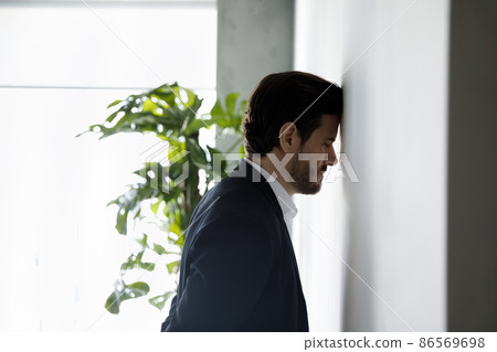 Frustrated desperate business man leaning head on wall 86569698