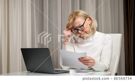 Blonde dame reads letter with bad news and feels stressed Blonde dame reads letter with bad news and feels stressed 86569734