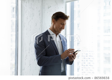 Happy focused business man using virtual app on smartphone 86569838