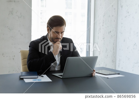 Busy serious business man working at computer in office 86569856