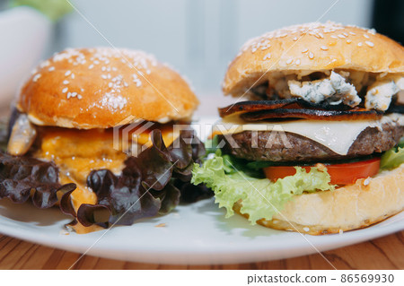 Burgers with beef and vegetables. Delicious burgers in a cooking class. Burger with onion sauce. Burgers with beef and vegetables. Delicious burgers in a cooking class. Burger with onion sauce. 86569930