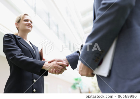Businessmen shaking hands in the lobby of the building 86569980