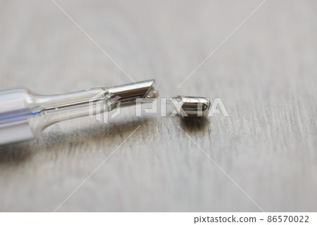 Broken mercury thermometer on a gray background, blurry Broken mercury thermometer on a gray background, blurry 86570022
