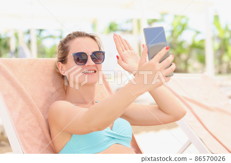 A woman in a swimsuit lies on a sun lounge, close-up 86570026