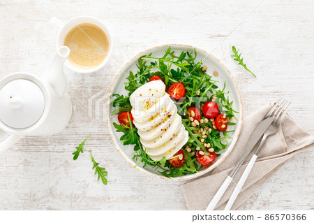 Salad with arugula, mozzarella cheese and pine nuts. Breakfast. Ketogenic, keto or paleo diet. Healthy food. Top view Salad with arugula, mozzarella cheese and pine nuts. Breakfast. Ketogenic, keto or paleo diet. Healthy food. Top view 86570366