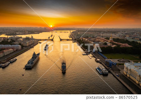 Aerial landscape with warships in the Neva River before the holiday of the Russian Navy at early morning, warships pass under a raised drawbridge, the latest cruisers among landmarks, Palace bridge 86570525