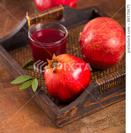 pomegranate juice and pomegranate fruits on a wooden background pomegranate juice and pomegranate fruits on a wooden background 86570675