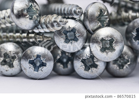 Close up of a pile of multipurpose metal screw heads Close up of a pile of multipurpose metal screw heads 86570815