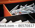 Close up of pile of metal screws in a toolbox 86570817
