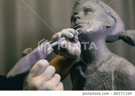 Man sculptor creates sculpt bust human woman sculpture with hammer. Statue craft creation workshop. Man sculptor creates sculpt bust human woman sculpture with hammer. Statue craft creation workshop. 86571184