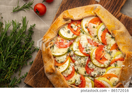 Part of homemade savory galette with vegetables, wholegrain pie with tomatoes 86572016