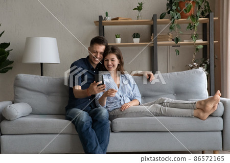 Happy bonding young family couple using smartphone. Happy bonding young family couple using smartphone. 86572165