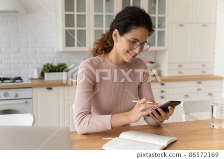 Woman holding smartphone and pencil, check schedule planning household Woman holding smartphone and pencil, check schedule planning household 86572169