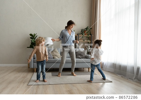 Happy young single mother dancing with cute kids. Happy young single mother dancing with cute kids. 86572286
