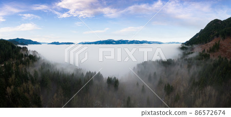 Aerial Panoramic View of Canadian Mountain Landscape covered in fog over Harrison Lake 86572674