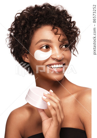 African American skincare models with perfect skin and curly hair with patches under her eyes . Beauty spa treatment concept. African American skincare models with perfect skin and curly hair with patches under her eyes . Beauty spa treatment concept. 86573252
