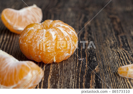 peeled ripe juicy tangerine on a wooden table peeled ripe juicy tangerine on a wooden table 86573310