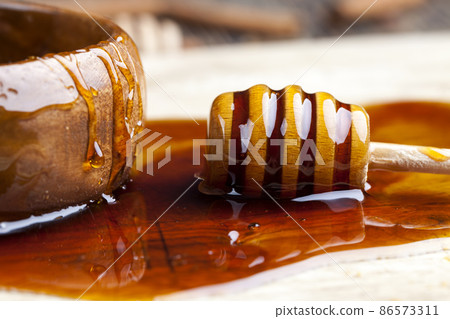fresh bee honey poured on a board fresh bee honey poured on a board 86573311