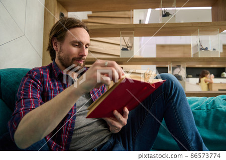 Close up of young Caucasian man reading book at home. Education, study, knowledge and erudition concept 86573774