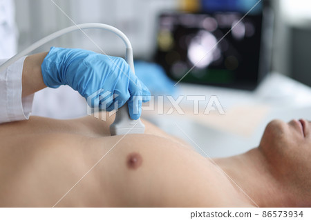 Doctor performs chest ultrasound on man in hospital closeup 86573934