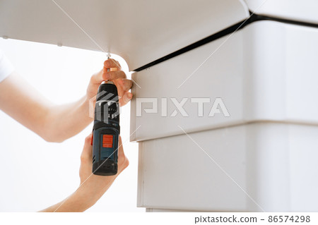 hand of engineer with screwdriver assembles medical equipment after repair 86574298