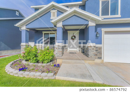 Blue two-storey house exterior with landscape garden and attached garage 86574792