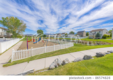 Small playground with white picket fence in community at Utah 86574828
