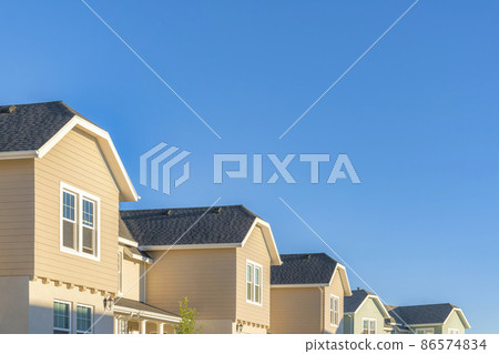 Row of houses with vinyl wood sidings and jerkinhead roofs structure Row of houses with vinyl wood sidings and jerkinhead roofs structure 86574834