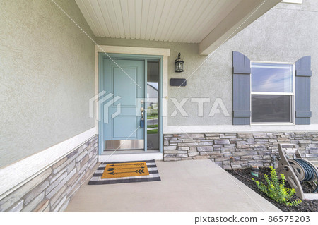 Light blue front door with lockbox and doormat on a concrete entrance 86575203
