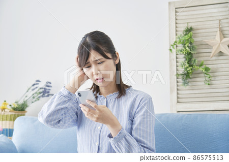 Female troubled smartphone living room 86575513