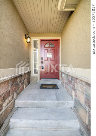 Concrete doorstep of a house with red front door and wall lamp Concrete doorstep of a house with red front door and wall lamp 86575817