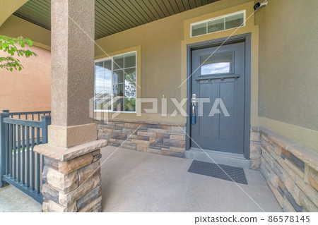 Front porch with security camera above the gray front door with window panel and lockbox 86578145