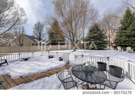 Outdoor patio on a deck of a house with metal chairs and table 86578276