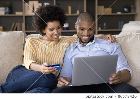 African couple buying goods on internet use card and laptop 86578420
