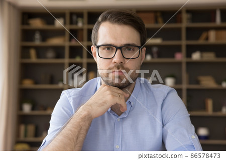 Head shot concentrated pensive young man looking at camera. 86578473