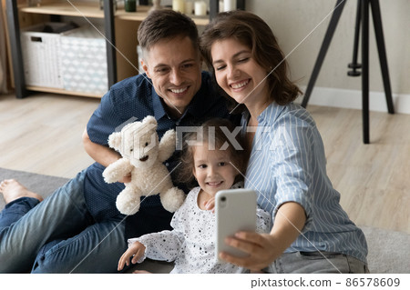 Smiling young mother posing for selfie with husband and daughter. Smiling young mother posing for selfie with husband and daughter. 86578609