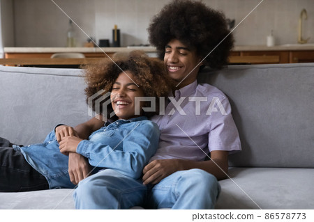 Happy dating teenage couple in love relaxing on home couch 86578773