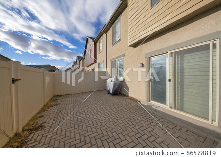 Backyard of a complex houses with sliding door and fence 86578819