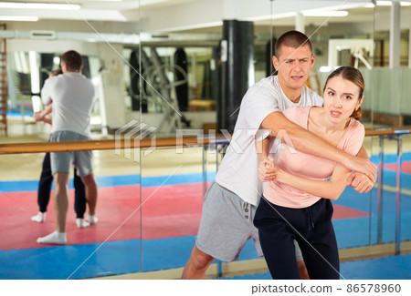 Woman learning elbow strike move during self-defense training 86578960