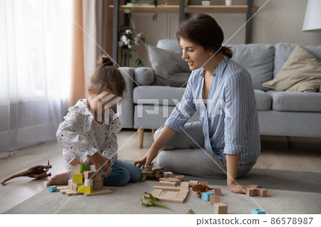 Loving young single mum playing toys with small daughter. Loving young single mum playing toys with small daughter. 86578987