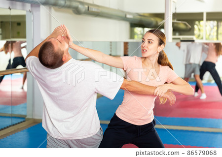 Woman performing chin strike during self-defence training 86579068