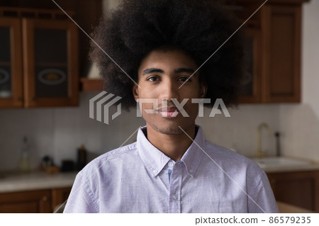 Positive African teenage guy with Afro hairdo home head shot Positive African teenage guy with Afro hairdo home head shot 86579235
