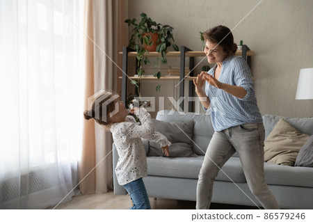 Overjoyed small kid girl dancing with mum. 86579246